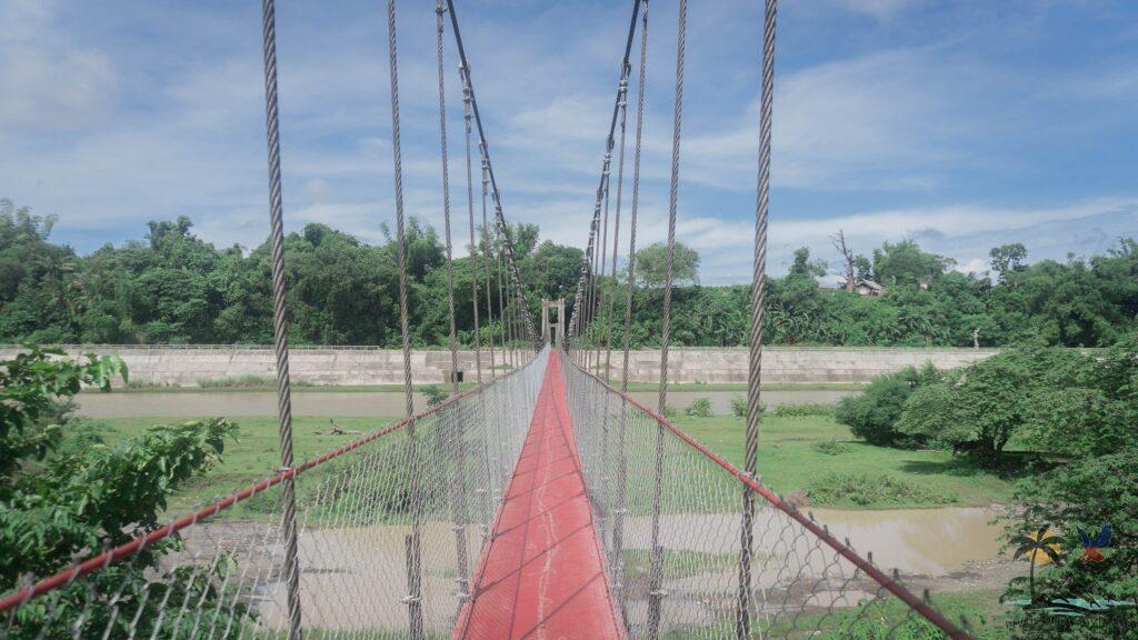 Red footbridge crossing the Guimbal River